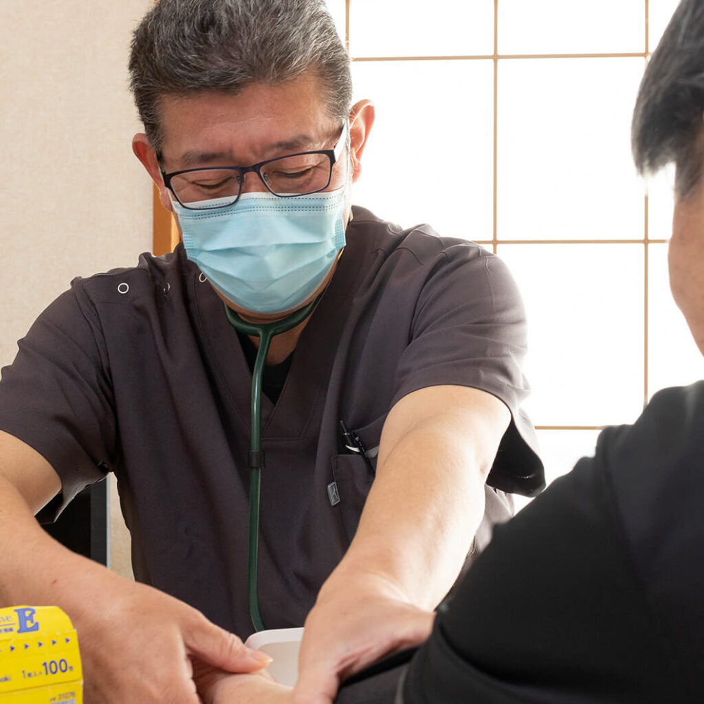 看護師が血圧計で腕の血圧を測定している様子